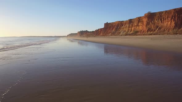 Aerial Flight Over a Beautiful Evening Beach at Low Tide and a Mirrored Surface That Reflects the