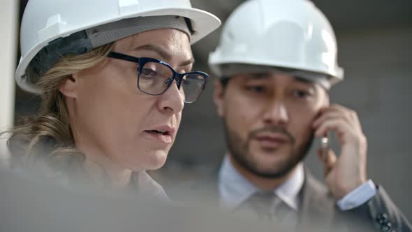 Businesspeople Discussing Construction Documents alt