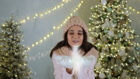 Beautiful Girl Blows on the Palms and Magically Creates Shimmering 3D Particles for Christmas