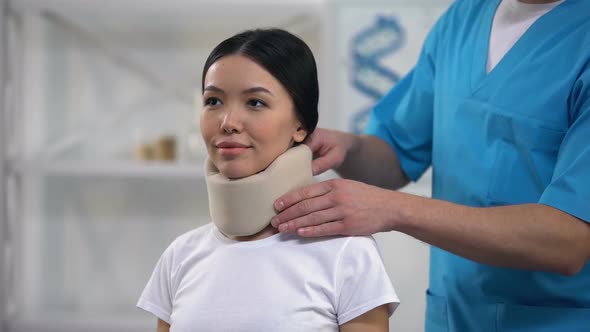 Male Physician Fixing Happy Female Patient Foam Cervical Collar, Rehabilitation