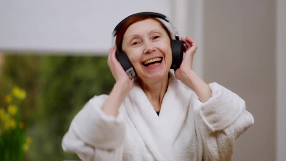 Portrait of Carferee Happy Mature Woman Smiling Looking at Camera Dancing Listening to Music in