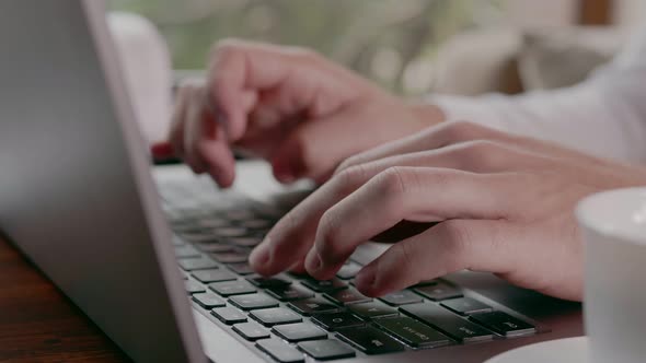 Freelancer Typing on a Laptop in a Cafe