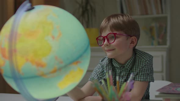 Preschool Boy Exploring Earth Globe at Home