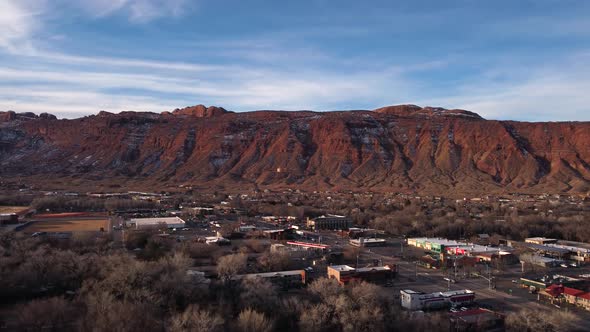 Flying toward the red rock canyon wall in Moab Utah during golden hour, aerial