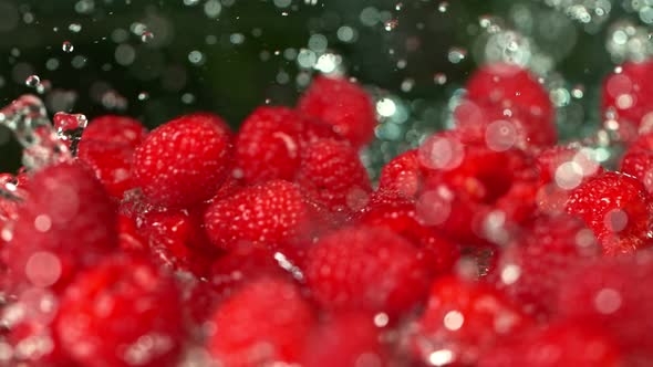 Super Slow Motion Shot of Fresh Raspberries Falling Into Water and Splashing at 1000Fps.