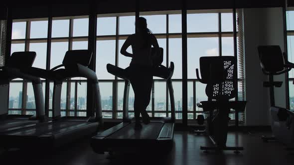 Young Fit Woman Running on Treadmill in Gym Back View. Cardio Training Weight Loss Motivation