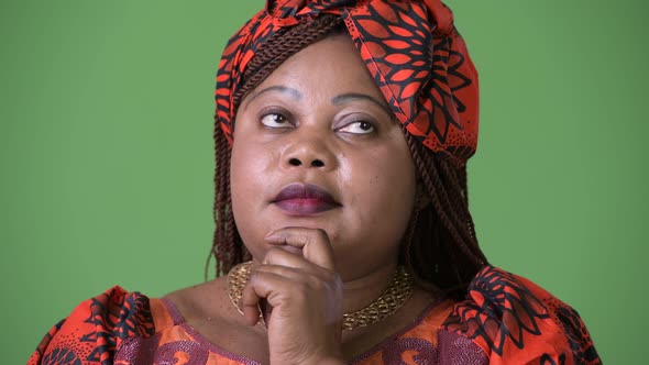 Overweight Beautiful African Woman Wearing Traditional Clothing Against Green Background