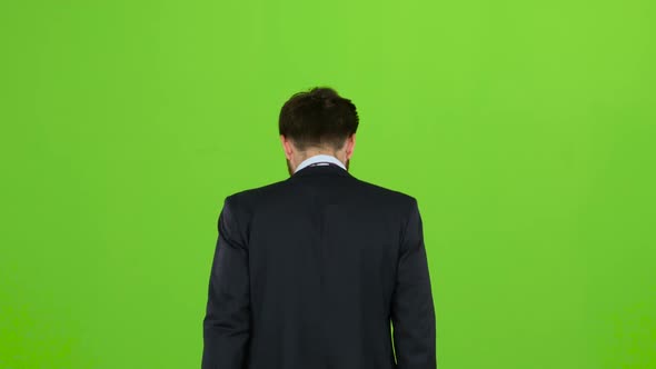 Businessman Goes To Work, with a Diplomat He Waves His Hand To Others. Green Screen. Back View
