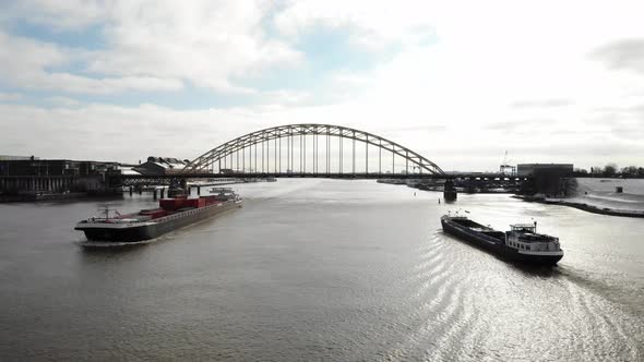 Cargo Ships Sailing Across The River Under The Bridge Over Noord In Netherlands. wide shot