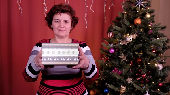 Woman Gives a Gift for Christmas. Concept of Holidays, Christmas and New Year.