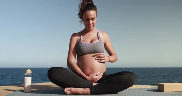 Pregnant woman doing yoga outdoor - Meditation and maternity concept for an healthy lifestyle