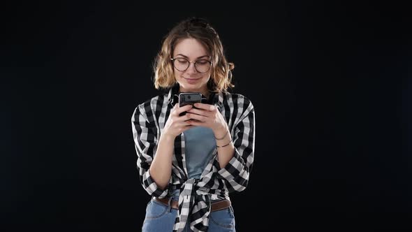 Portrait of Concentrated European Woman Wearing Casual Clothing Plaid Shirt and Jeans Holding