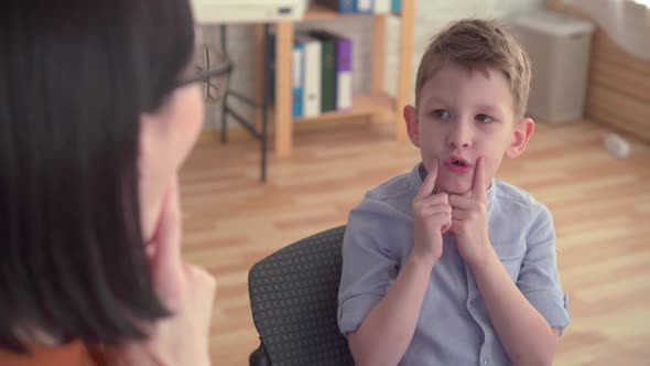 Closeup of a Speech Therapist Deals with a Little Boy