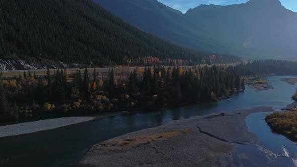 Highway in mountains by river with powerlines and parked car