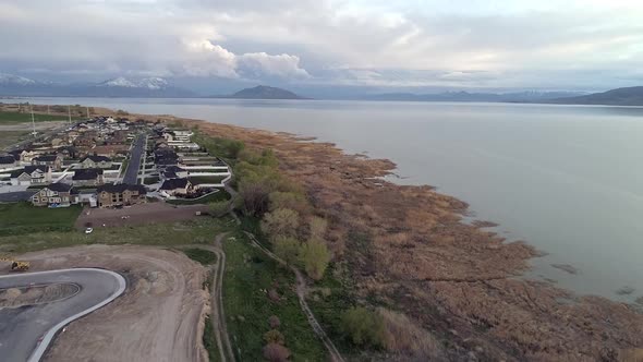 Flying over lake side viewing new construction area next to homes