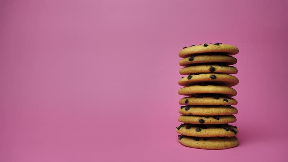 A Stack of Chocolate Chip Cookies Sprouting on a Pink Background