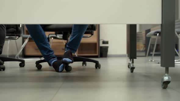 Many people in office cross their legs and put one to another. Unrecognizable persons in socks