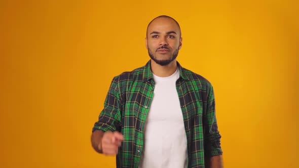 Funny African American Man Came Up with an Idea with Raised Finger Against Yellow Background