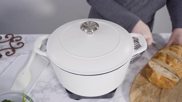 Cooking vegetarian white bean soup in cast iron dutch oven.