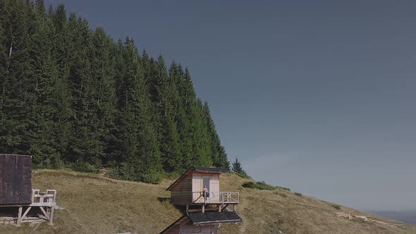 Aerial view of wooden houses on an carpatian meadow among mountains