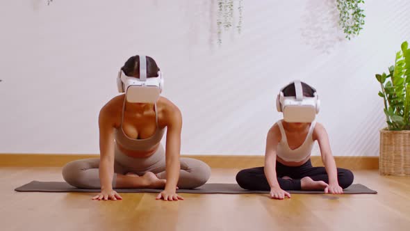 Mom and kid doing yoga child's pose at home together,VR goggles in modern lifestyle.Practice yoga wo