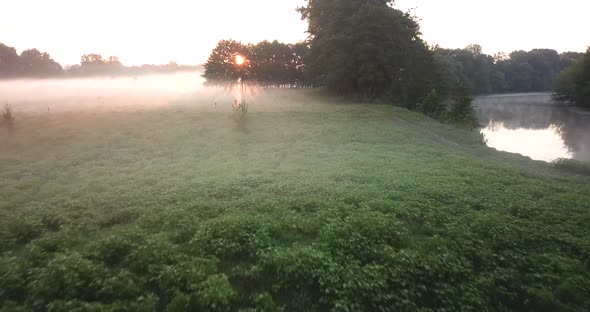 Aerial View of the Meadow and River Covered with Fog at Dawn