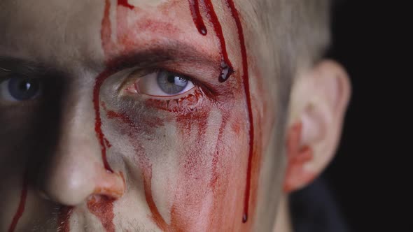 Halloween Man Portrait. Guy with Dripping Blood on His Face. Scary Makeup