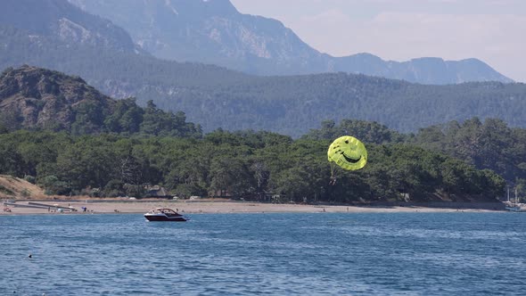 Parachute Flying Over Water with Mountains on Background