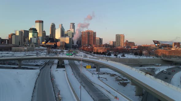 Minneapolis downtown skyline aerial footage during a winter golden hour, highways covered with snow,