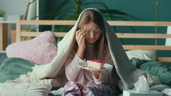 Heartbroken Young Woman Sitting on Sofa Crying Eating Cake Using Tissues