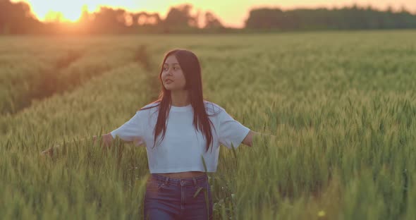 Oriental Young Woman is Walking Alone on Beautiful Rye Field in Sunrise Portrait  Prores