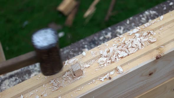 Carpenter Hammering Wood Bar Into Wood