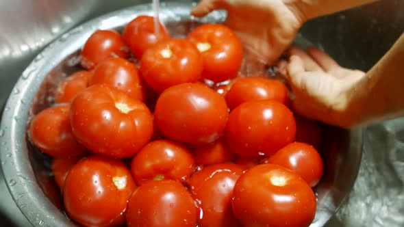 Hands Washing Tomatoes in Basin.