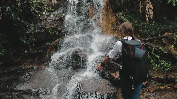 Woman Tourist Reach Out To Splashing Waterfall