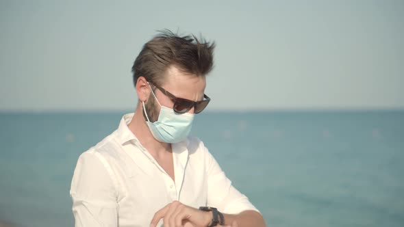 Sad Man In Face Mask At Covid Looking On Sea New Normal. Lockdown On Vacation. Covid-19 Pandemic.