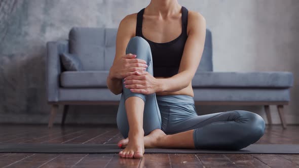 Young and sporty girl in sportswear is doing exercises in home interior.