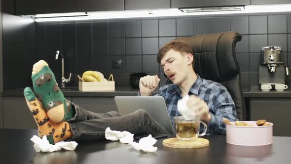 Man with cold, coughing and sneezing working from home office 