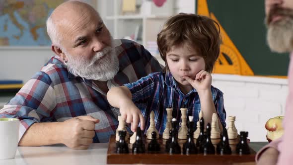 Grandson Playing Chess with Grandfather and Father at Home. Child and Childhood, Clever Concentrated