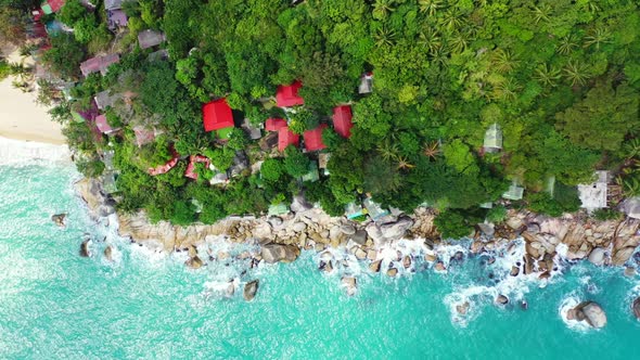 Aerial drone shot sky of luxury coastline beach holiday by blue water with white sandy background of