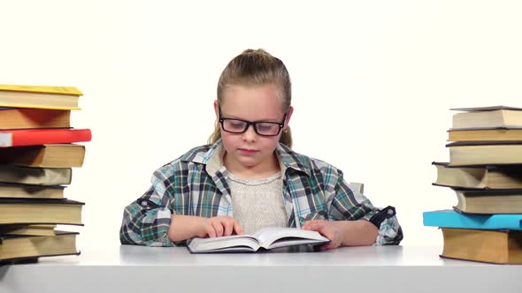 Girl Chooses a Book and Starts To Read It. White Background