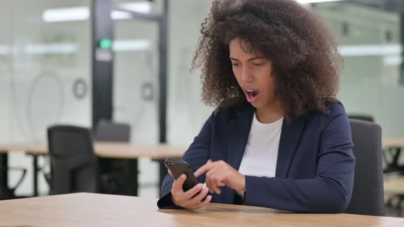 Young African Businesswoman Reacting To Loss on Smartphone 