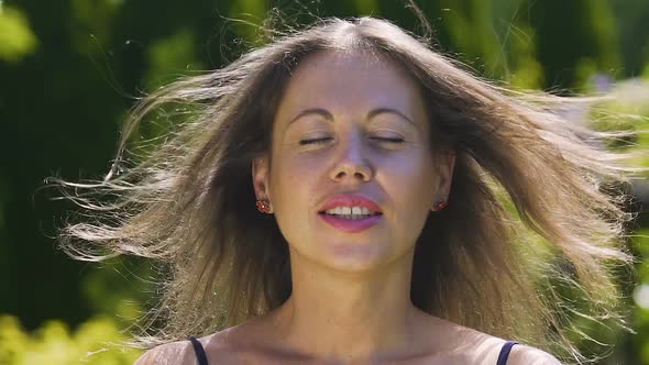 Female Enjoys Herself as Wind Blows Up Hair, Eyes Close, Happiness and Joy Slow