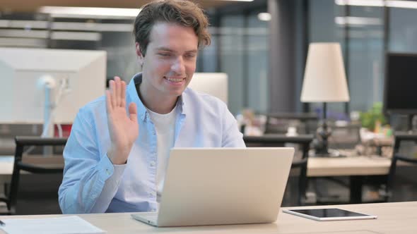 Man Talking on Video Call on Laptop in Office