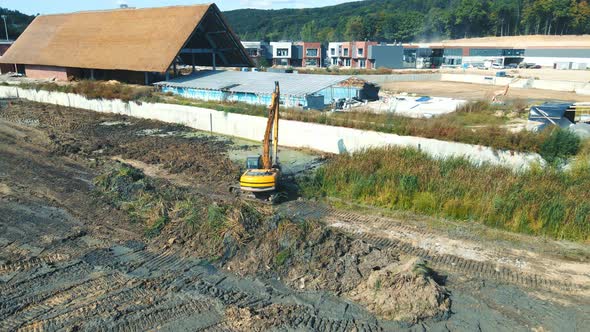 Aerial View Work of an Excavator That Clears and Levels the Area