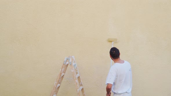 Painter Man Painting a Wall with a Roller