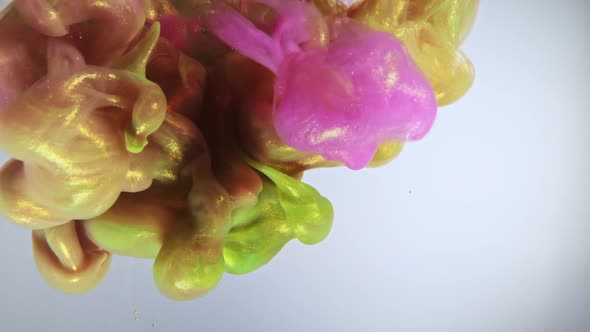 Colorful Nacreous Paint in Water Against White Background.