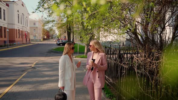 Two females talking and eating ice cream outdoors. Girlfriends spending summer time together