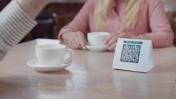 Close Up of Man Scan Qrcode Wth Smartphone and Pay in Restaurant