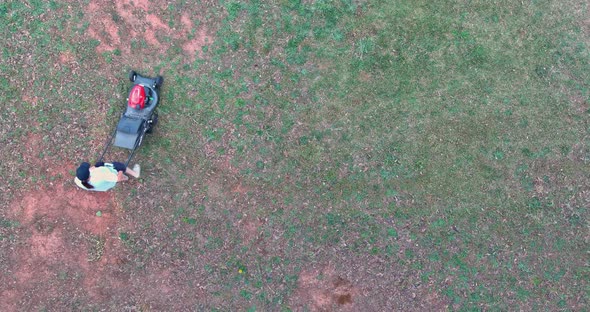 Aerial View of Women Working Lawn Mower on Green Lawn with Trimmed Grass in Garden Care Work Tool