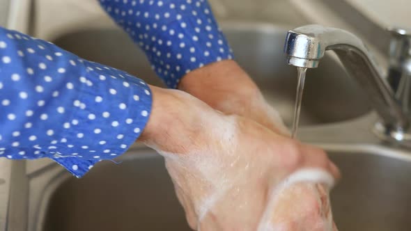 Caucasian woman washing her hands with soap at home